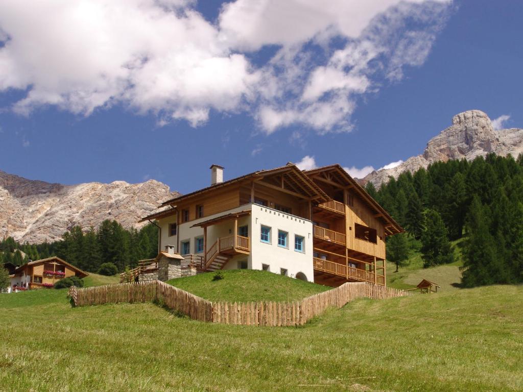 a house on top of a hill in a field at Apartments Serghela in San Cassiano