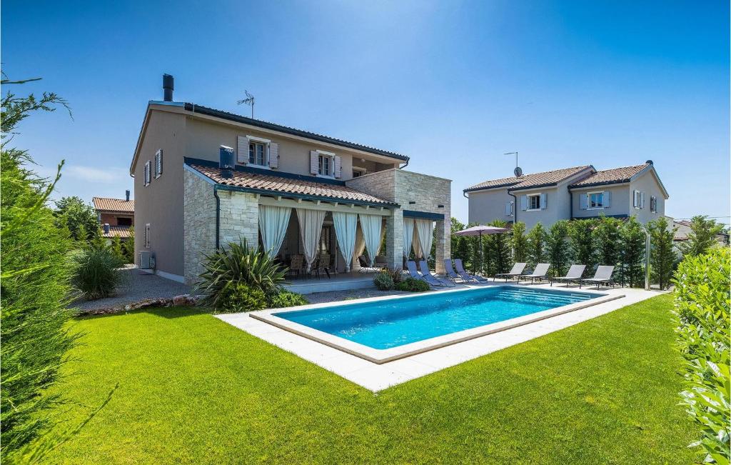 a house with a swimming pool in front of a yard at Villa Calma in Šivati