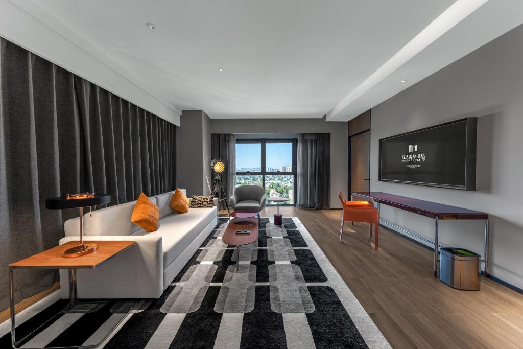 a living room with a couch and a tv at Wanda Moments Hotel Beijing Dongba in Beijing
