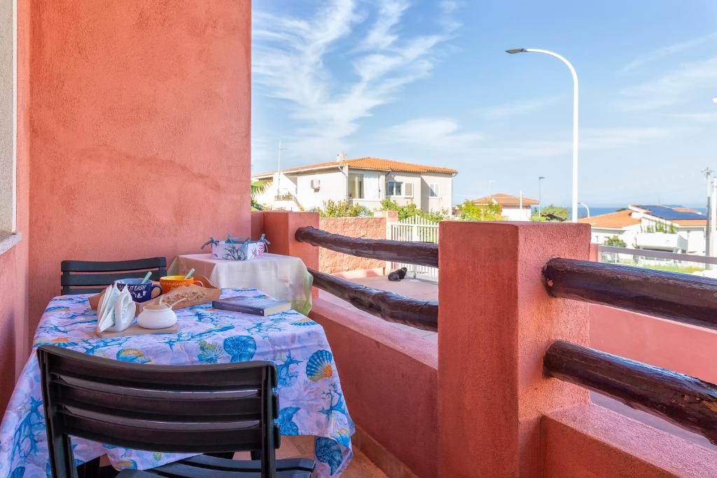 une table et des chaises assises sur un balcon dans l'établissement La Casa Al Mare, à Castelsardo