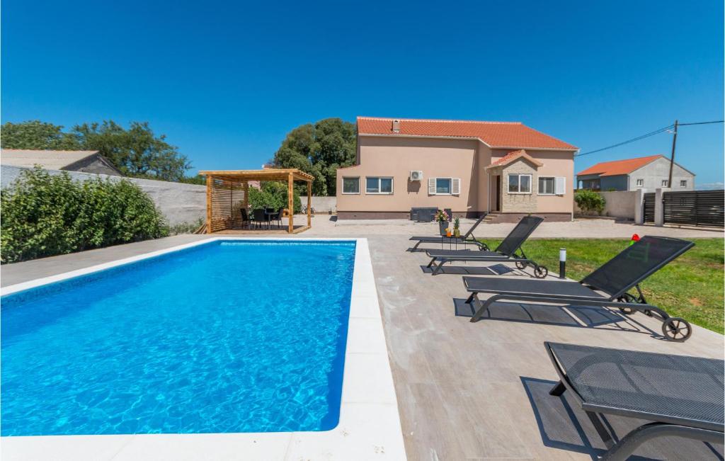 basen z leżakami i dom w obiekcie Cozy Home In Biograd Na Moru w Biogradzie na Moru