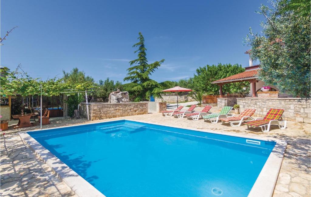 basen na dziedzińcu z krzesłami i altaną w obiekcie Lovely Home In Vodnjan w mieście Vodnjan