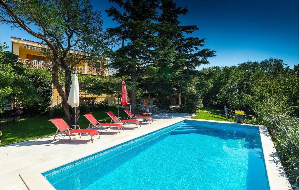 una piscina con un montón de sillas al lado en Villa Perla, en Jadranovo