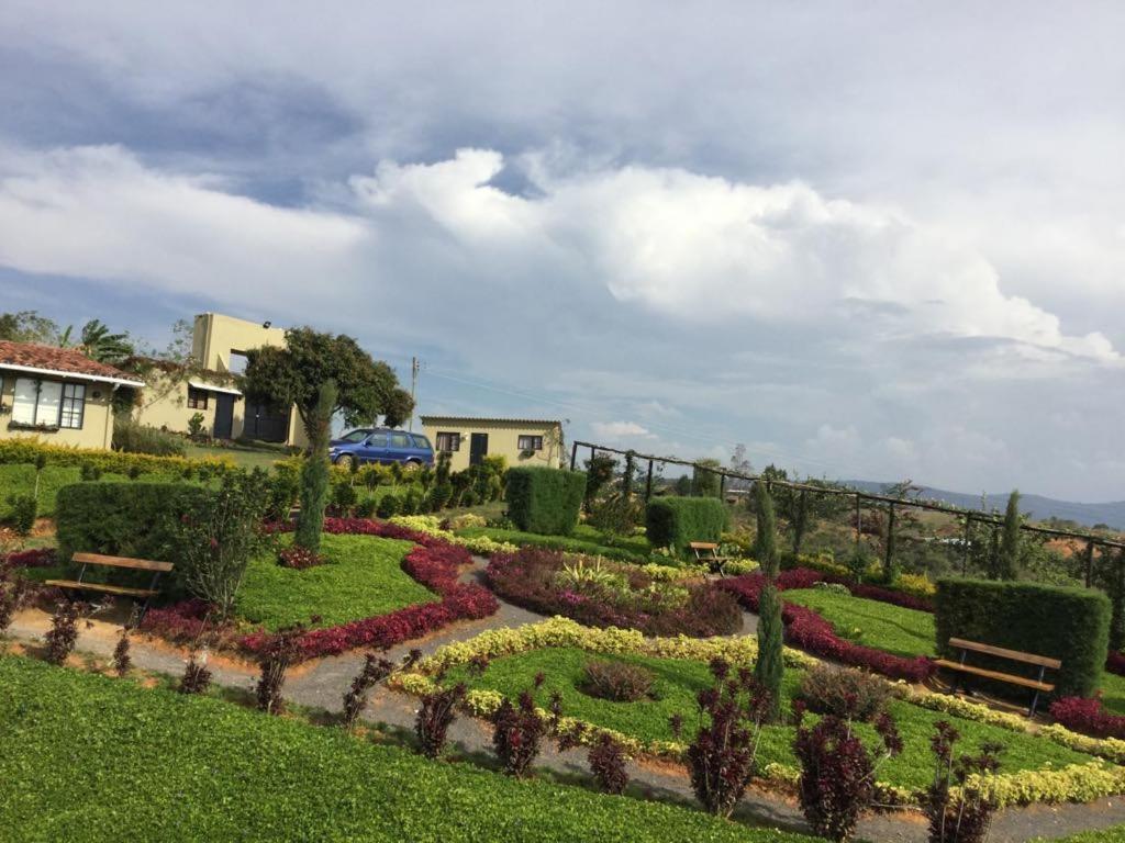 a garden with benches and flowers in a yard at Casa Emilia in Curití