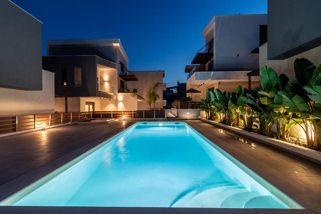 a swimming pool in front of a building at night at Diamond Gold Suite in Iraklitsa