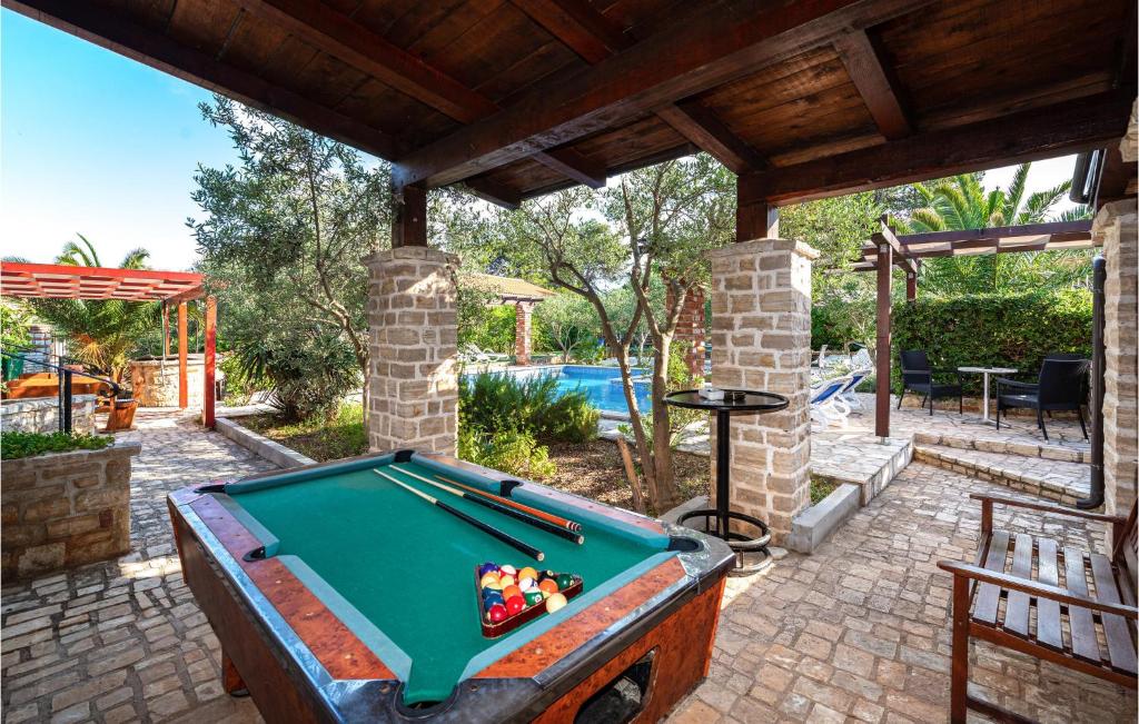 stół bilardowy znajduje się pod pawilonem z basenem w obiekcie Five-Bedroom Holiday Home In Vir w mieście Vir