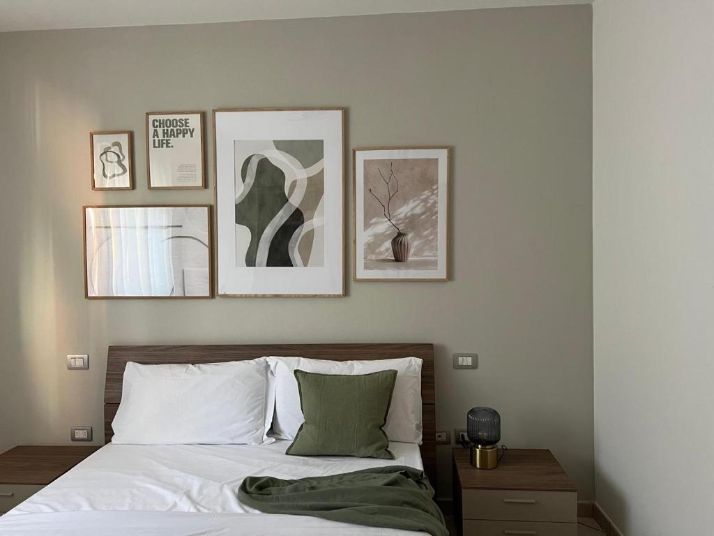 a bedroom with a bed with four pictures on the wall at La Fossola 25 - vicino al Bernina Express in Tirano