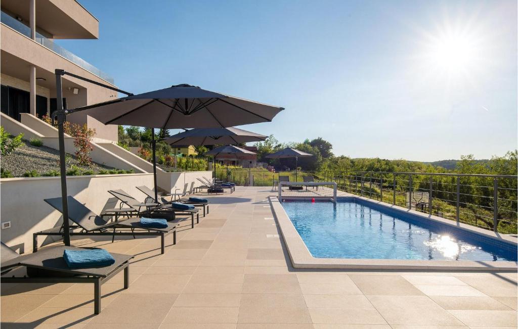 a swimming pool with lounge chairs and an umbrella at Villa Callista in Ružići