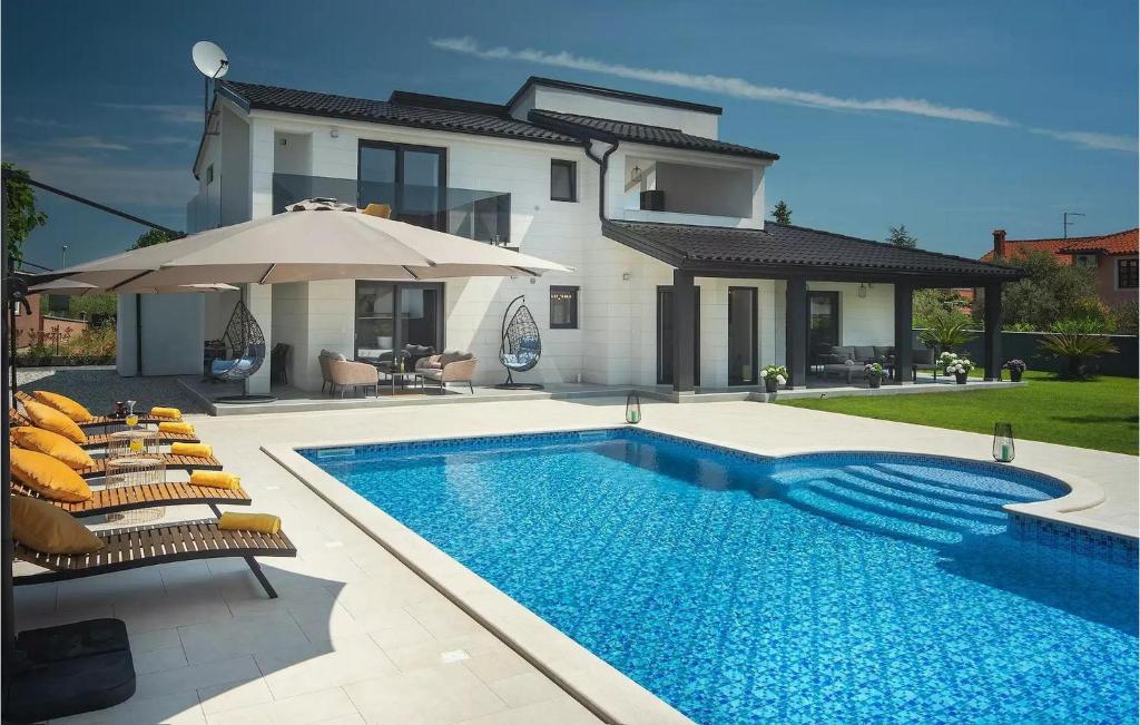 a swimming pool in front of a house at Villa D&V in Veli Vrh