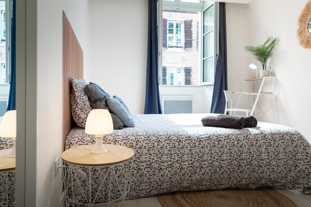una camera da letto con un letto e un tavolo con una lampada di La Bulle Paloise, Appartement, hyper-centre a Pau