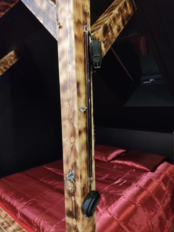 - une croix en bois au-dessus d'un lit dans l'établissement La Love room, à Arbois