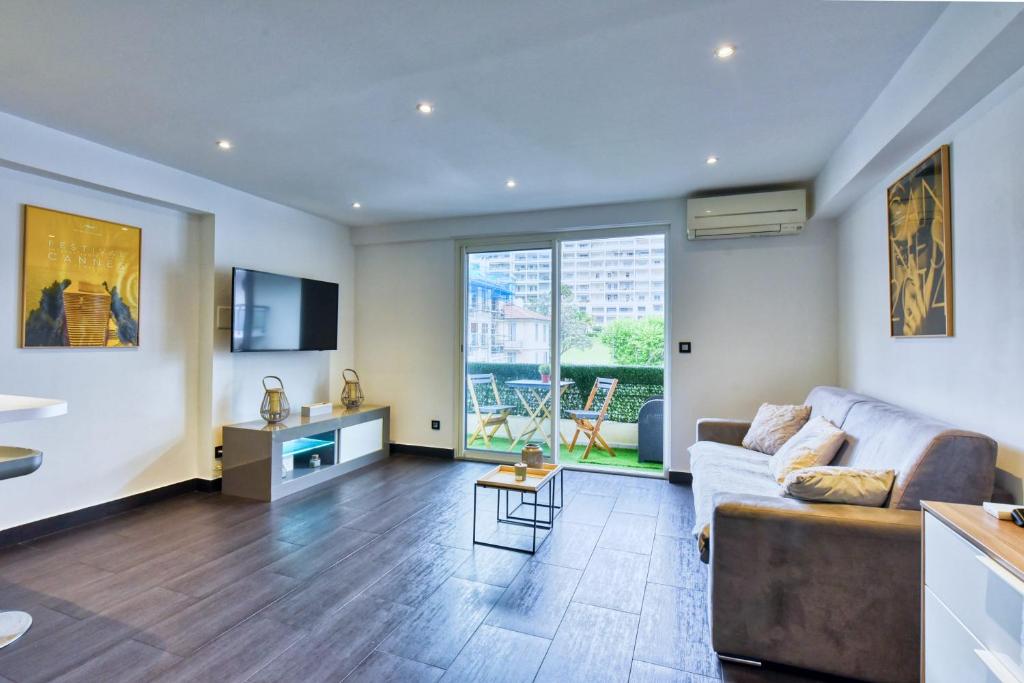 salon z kanapą i dużym oknem w obiekcie LE VENITIA studio raffiné avec balcon mignon, pour votre séjour à deux w Cannes