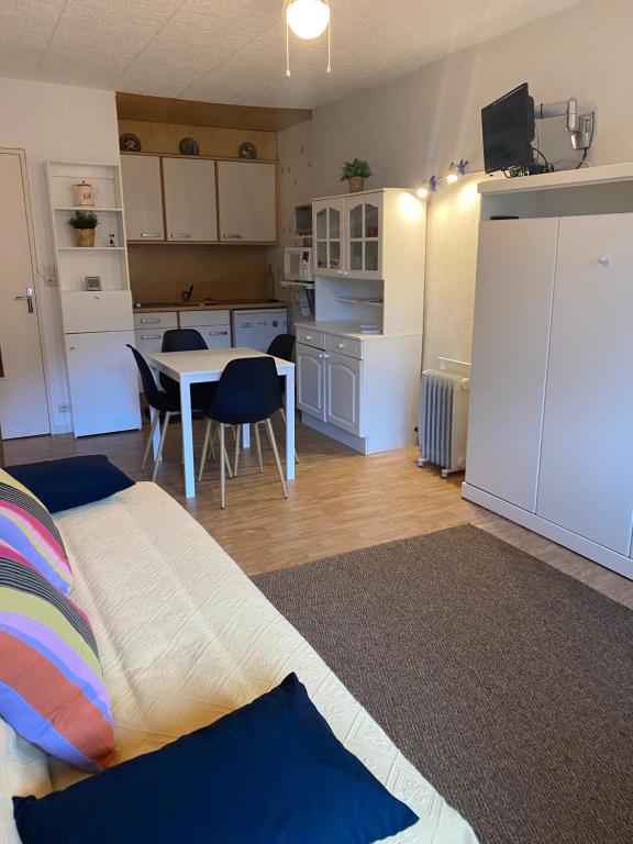 une chambre avec un lit et une cuisine avec une table dans l'établissement Les Cimes de Belle Hutte, à La Bresse