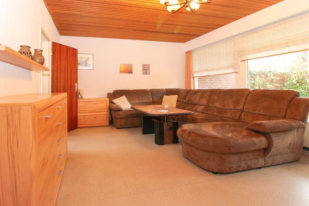 una sala de estar con un sofá y una mesa en Bungalow-Cara, en Norddeich