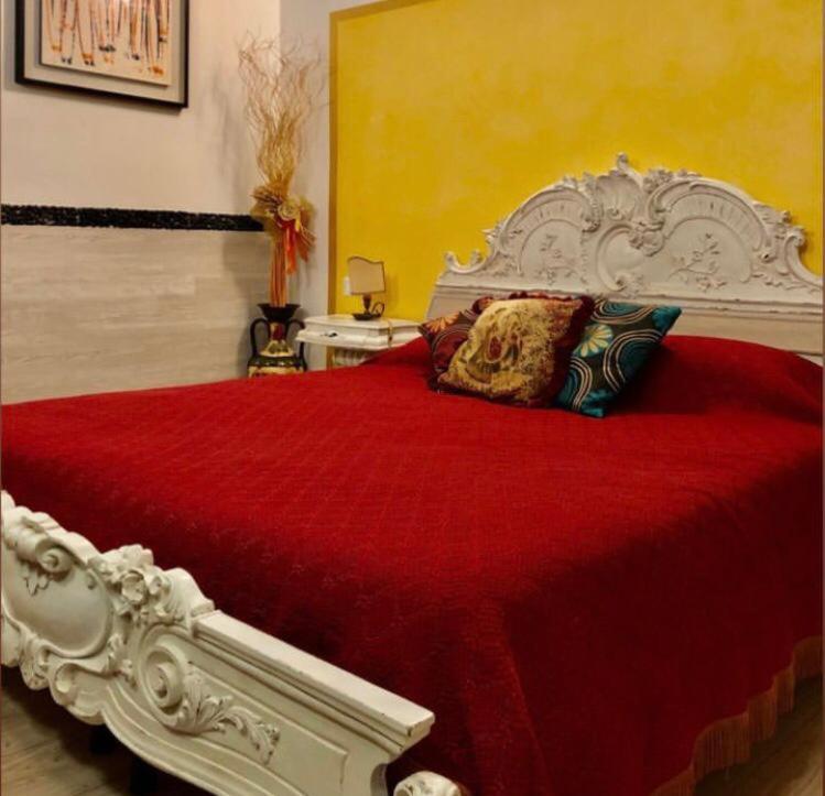 a bedroom with a large white bed with red sheets at CA' DI LUNA VENEZIA in Venice