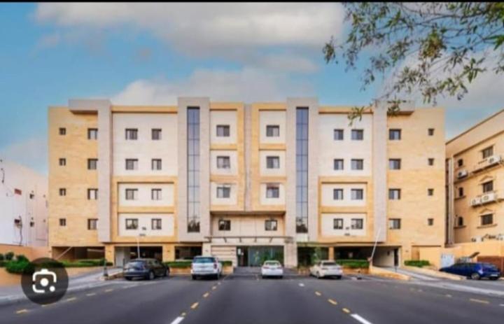 Palm Boutique Al Zahra بالم بوتيك الزهراء في جدة: مبنى كبير فيه سيارات تقف امامه