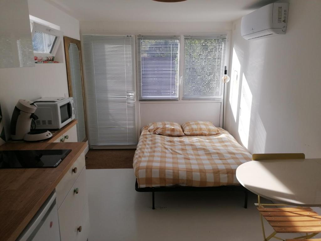 a small bedroom with a bed in a kitchen at Charmant studio - Terrasse - Parking gratuit in Montpellier