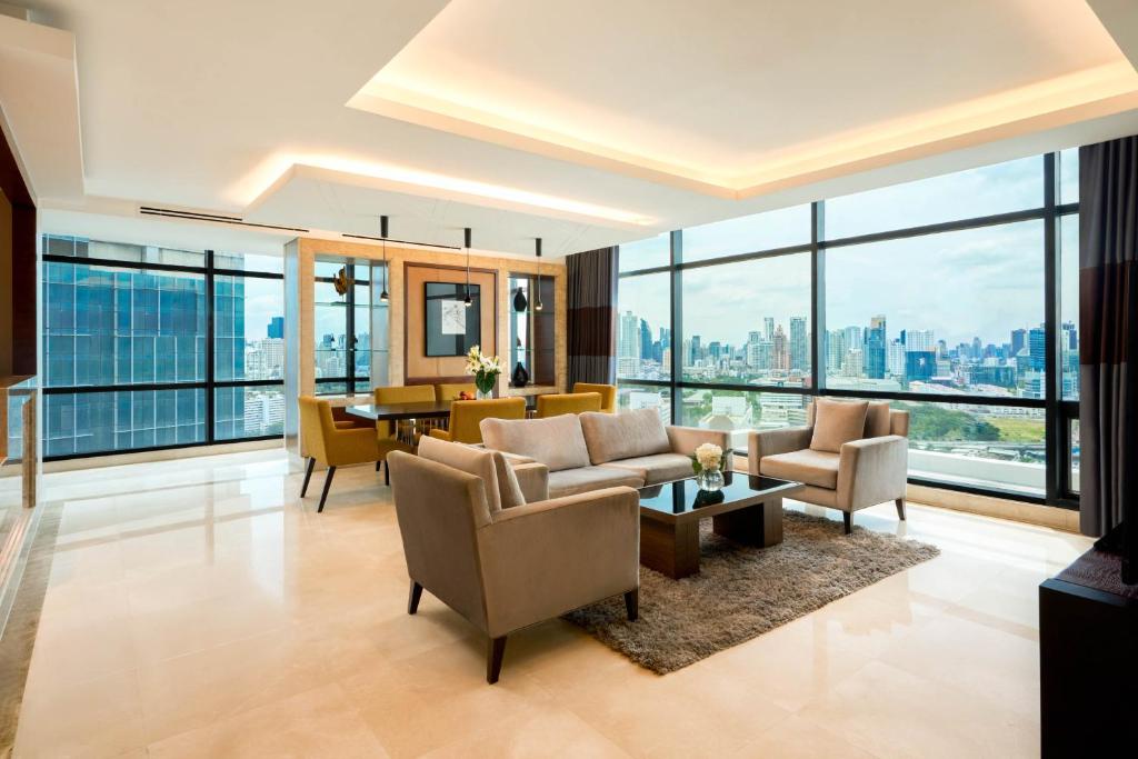 A large sitting room is arranged around panoramic corner windows and a city view.