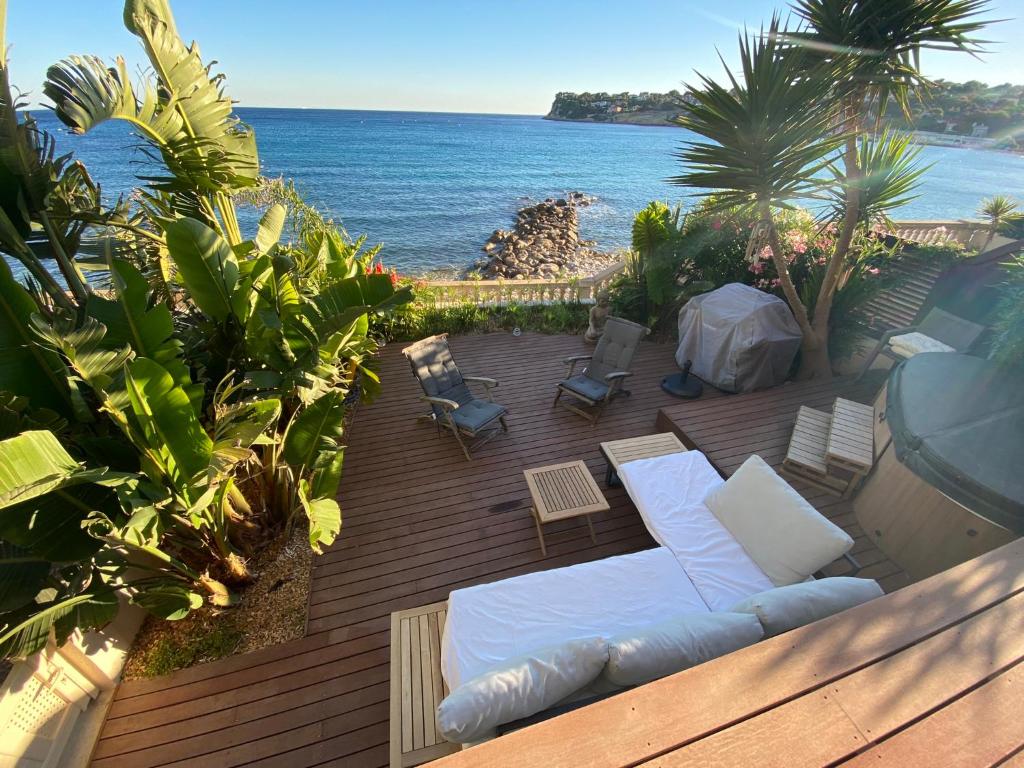 d'une terrasse avec un canapé et des chaises donnant sur l'océan. dans l'établissement PARADIS exceptionnel surplombant la MER- accès direct plage/ 8 Pers., à Carry-le-Rouet