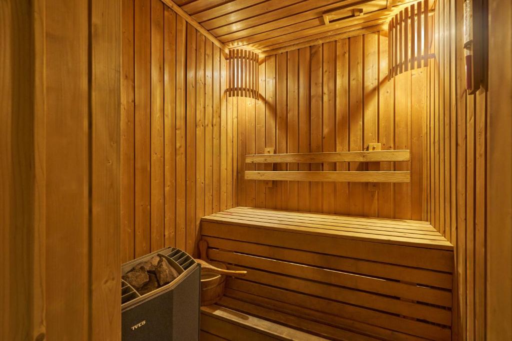 A compact wood-lined sauna with tiered benches and a visible heater.