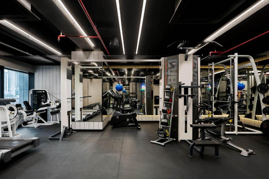 A modern fitness room with cardio and strength-training equipment.