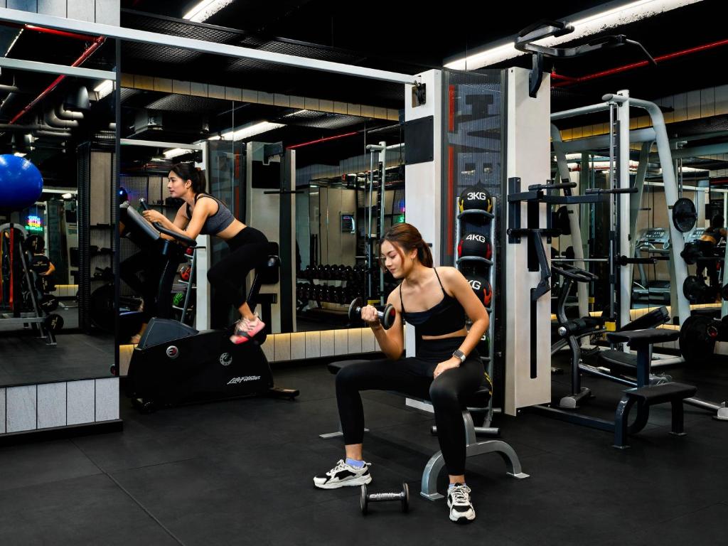 A mirrored fitness room with cardio and strength equipment.