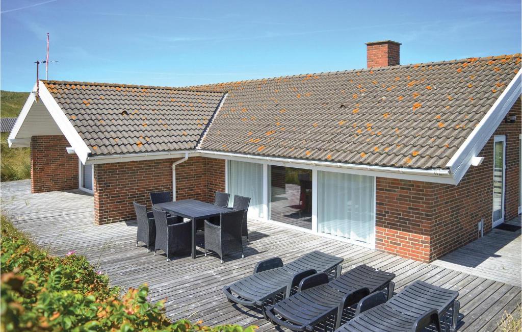 Casa con terraza con sillas y mesa en Pet Friendly Home In Hvide Sande, en Hvide Sande