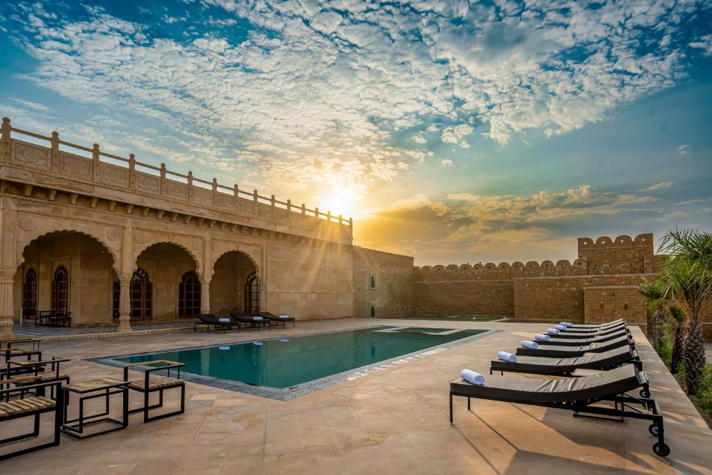 a swimming pool in a building with a sunset at Marugarh Camp and Resort Jaisalmer in Jaisalmer