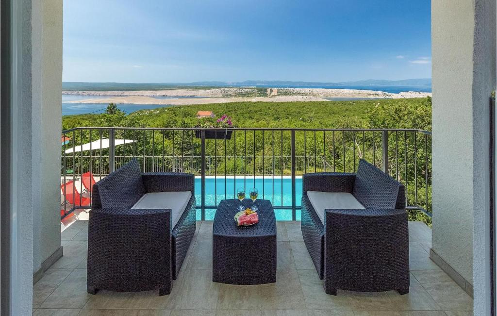 a balcony with two chairs and a table and a pool at Villa Aqua in Strimka