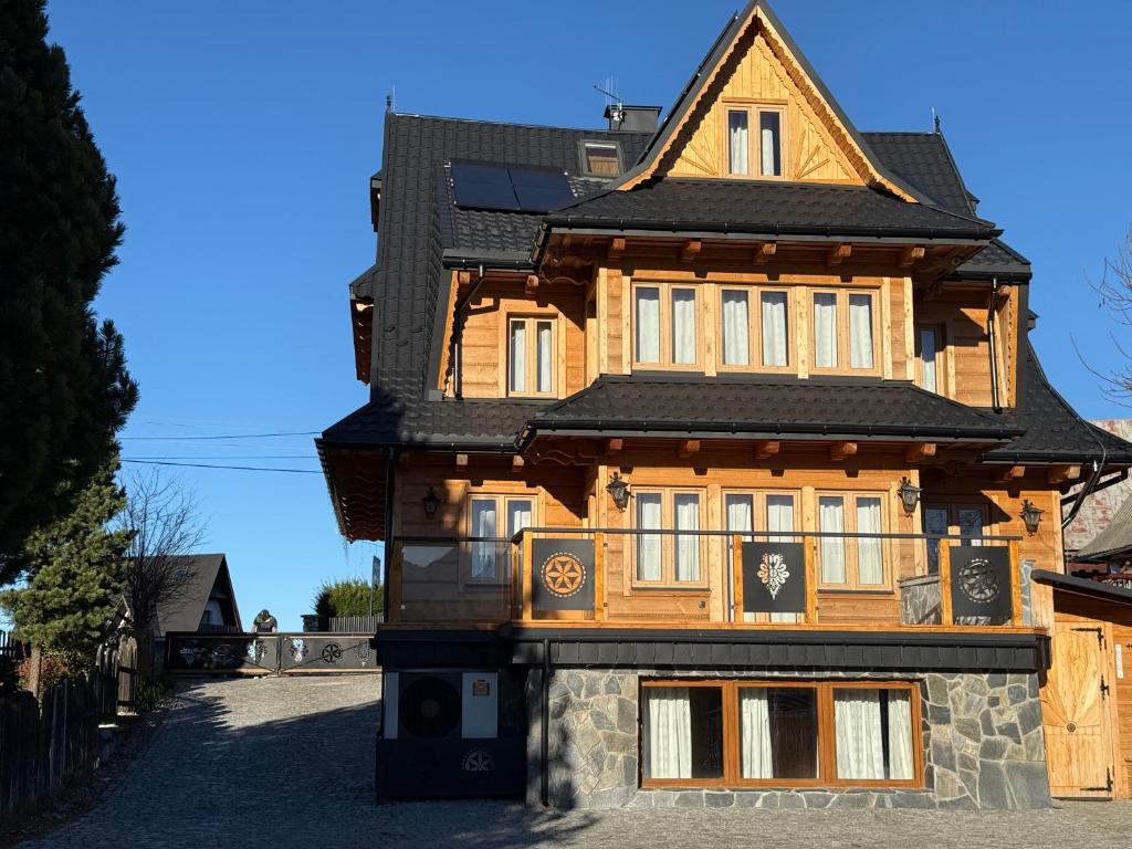 a wooden house with a black roof at Willa Ciżemka- sauna, tężnia solankowa in Bukowina Tatrzańska