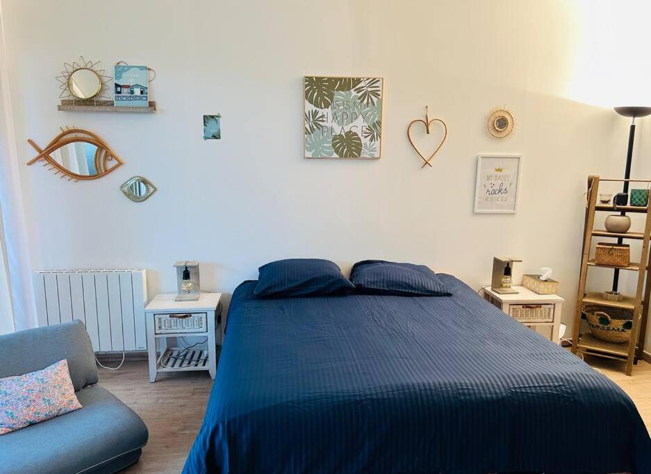 - une chambre avec un lit bleu et un canapé dans l'établissement La Seigneurerie Le Grand Studio, à Deauville