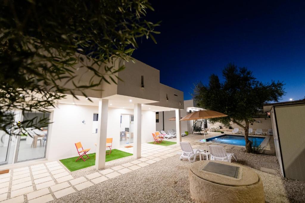una villa con piscina di notte di White houses luxury and pool a Scoglitti