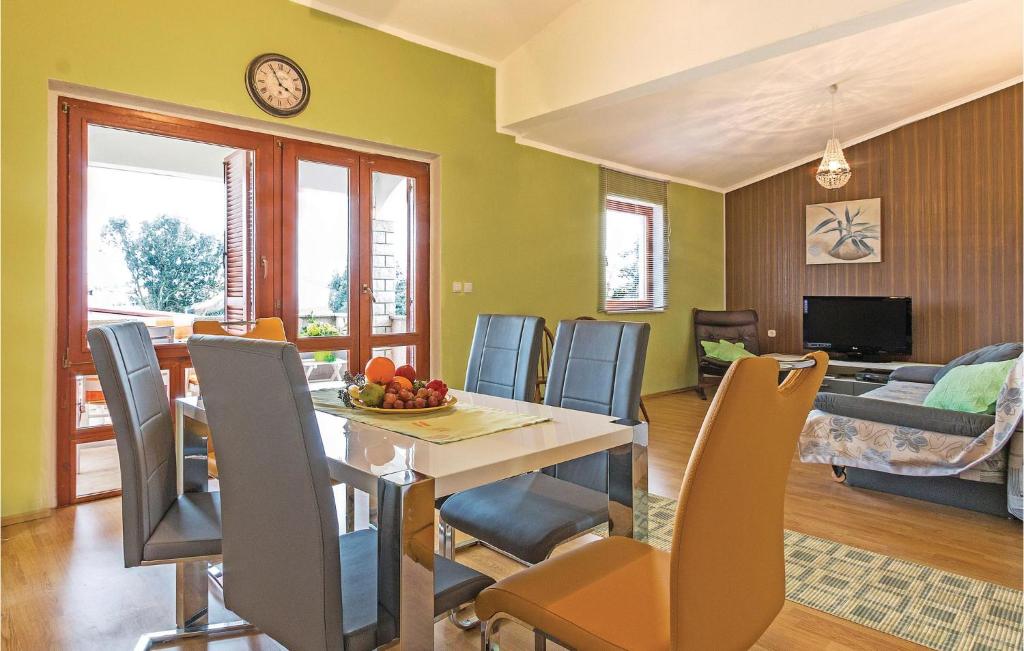 jadalnia i salon ze stołem i krzesłami w obiekcie Holiday Home Betiga With Sea View Vi w mieście Barbariga