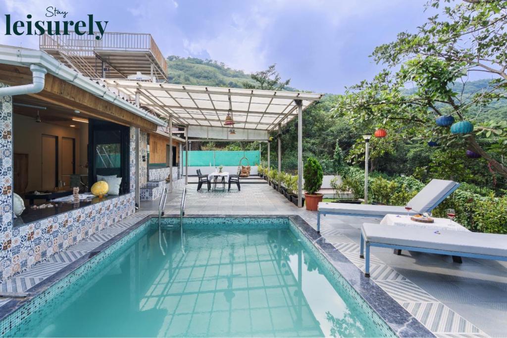 une piscine devant une maison dans l'établissement Stay Leisurely Pawna Lake Villa 3BHK, Pawna Lake, à Malavli