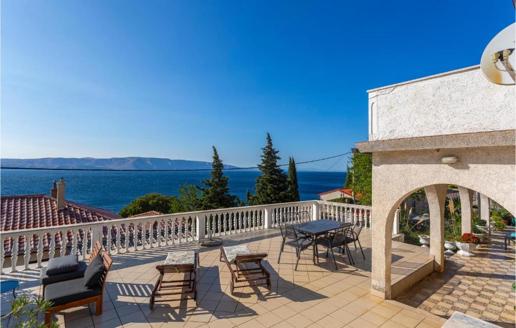 a patio with a table and chairs and the ocean at Awesome Home In Senj With Kitchen in Senj