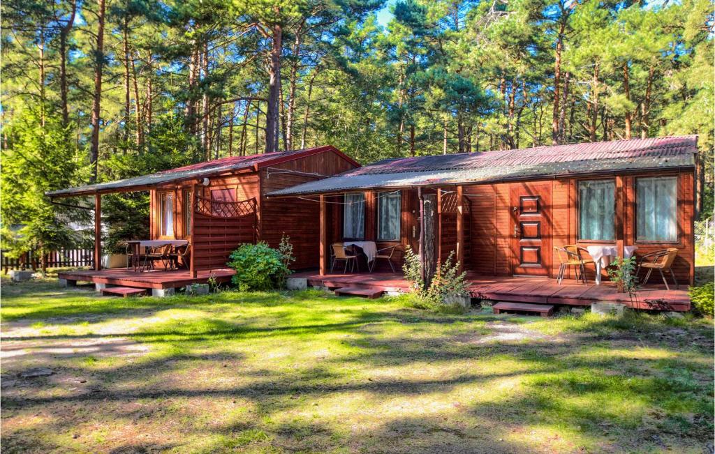 a log cabin in the woods with a yard at Beautiful Home In Pogorzelica in Pogorzelica