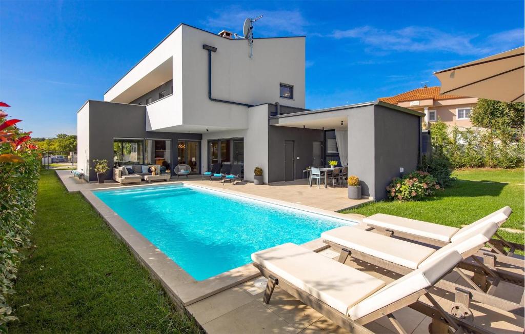 a villa with a swimming pool and a house at Villa Hedone Rakalj in Krasa