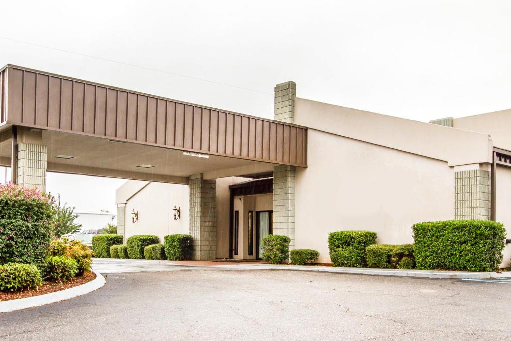 a large white building with bushes in front of it at Executive Inn and Suites in Enterprise