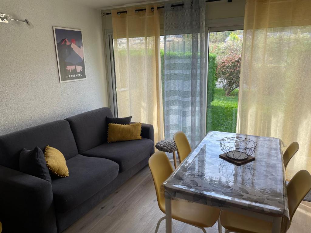 a living room with a couch and a table at Appt hyper centre Saint-Lary-Soulan village avec jardin in Saint-Lary-Soulan