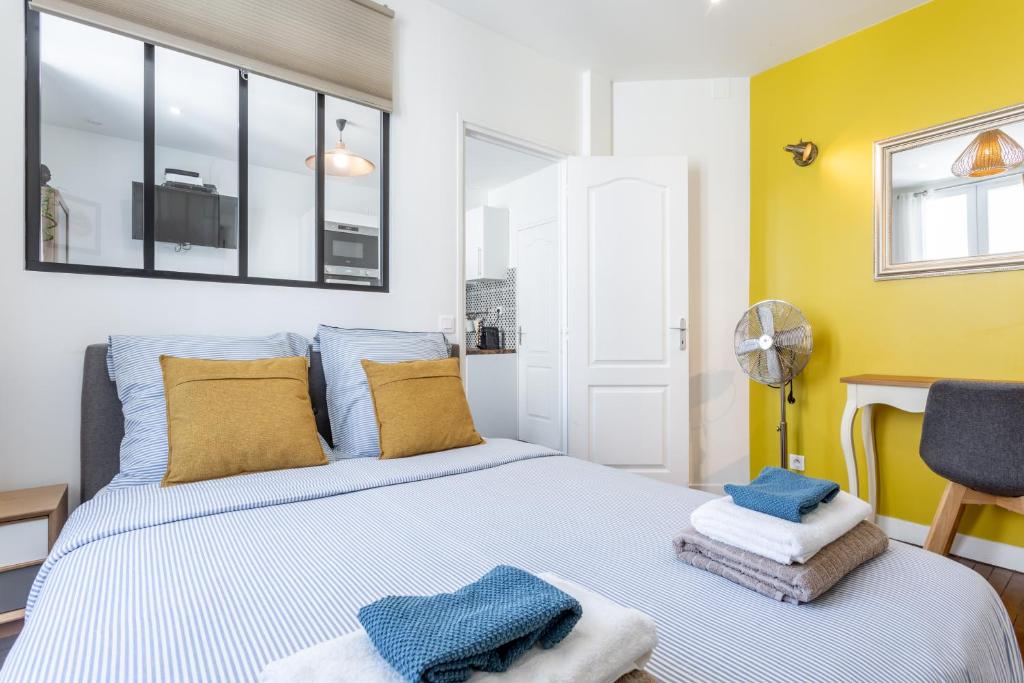 a bedroom with a bed with blue and yellow walls at Cosy 2 PIECES CHAMPS-ÉLYSÉES-DEFENSE in Puteaux