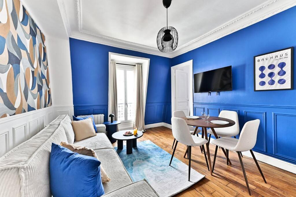 un salon bleu avec un canapé et une table dans l'établissement Appartement Paisible Centre de Paris - Bleu - II, à Paris