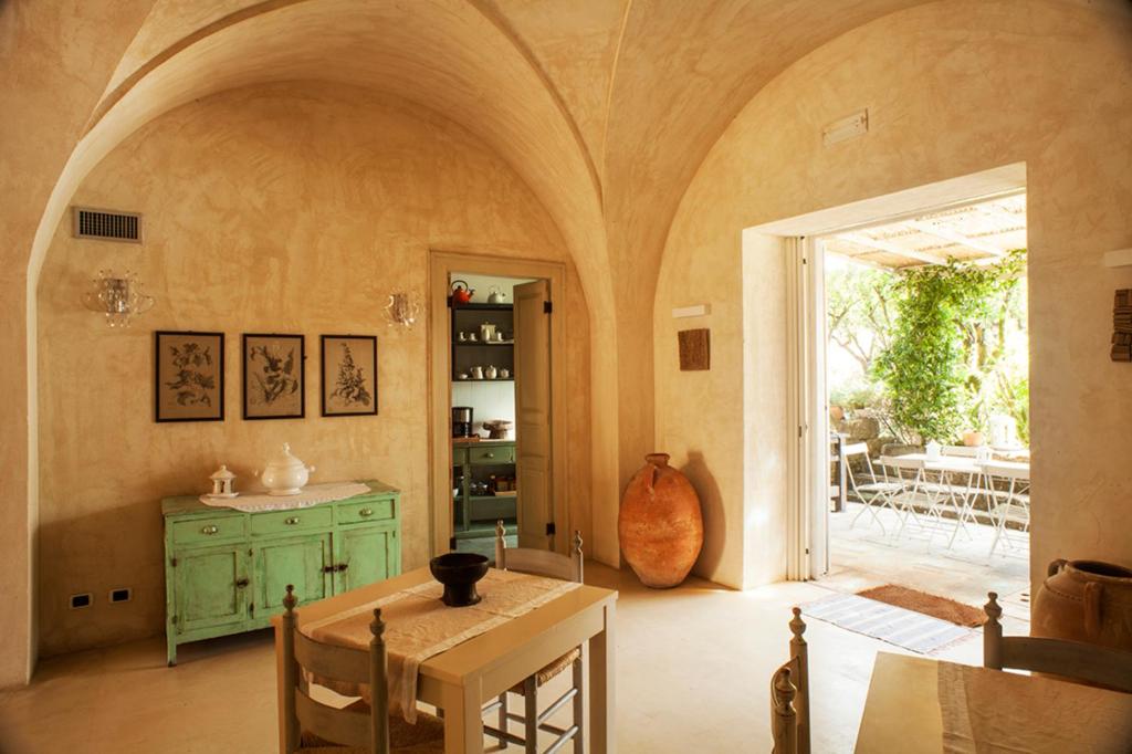 une salle à manger avec une table et une porte menant à une terrasse dans l'établissement Wp RELAIS LOCANDA FIORE DI ZAGARA, à Diso 30 autres photos