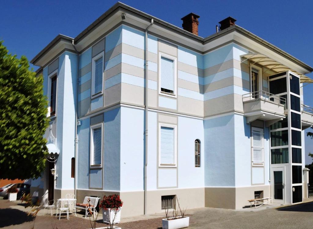 un edificio bianco e blu con balcone di Villa Ceirano a Lagnasco
