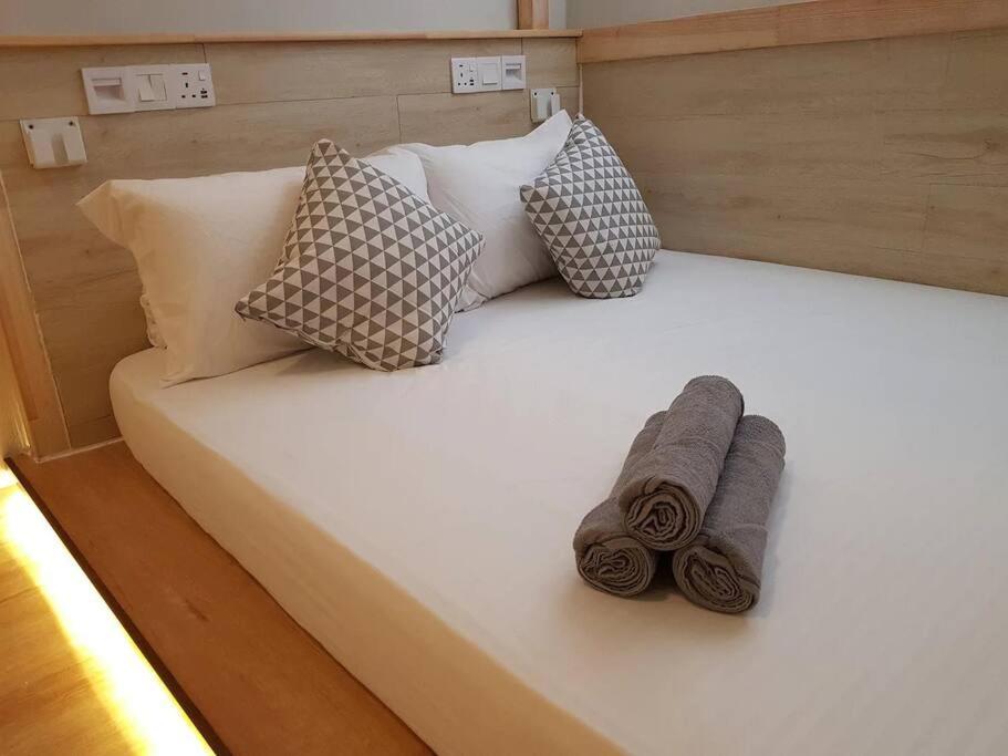 a white bed with pillows and towels on it at Heritage Loft on Beach Street near UNESCO Zone & Street Art 1 in George Town