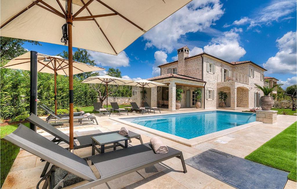a house with a swimming pool and an umbrella at Villa Elena in Rovinj