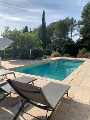 une piscine avec deux chaises et une table dans l'établissement Villa Faro, à Laouque