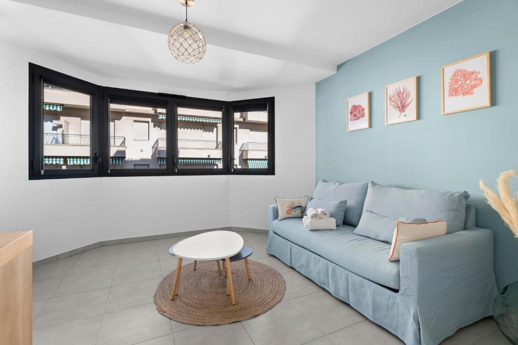 un salon avec un canapé bleu et une table dans l'établissement Studio Amanda - Welkeys, à Nice