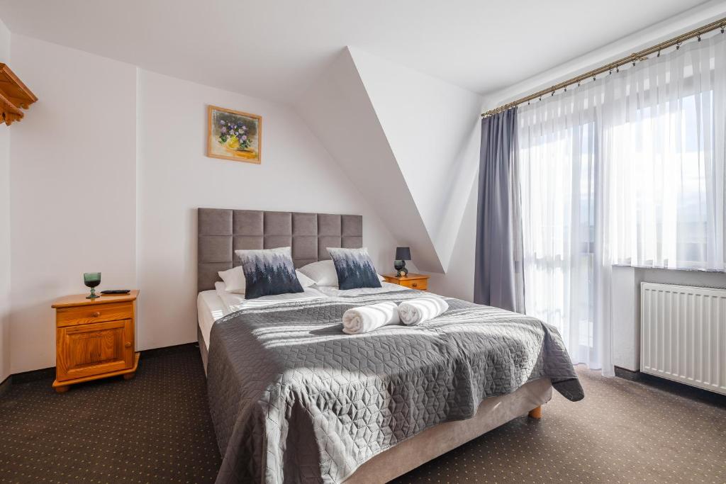 una camera da letto con un letto con due asciugamani sopra di Stasikowa Ostoja a Bukowina Tatrzańska