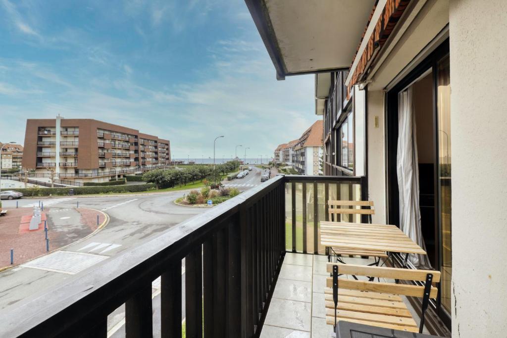 d'un balcon avec un banc et une vue sur la rue. dans l'établissement L'Estran - Appt 2p proche de la mer, à Villers-sur-Mer