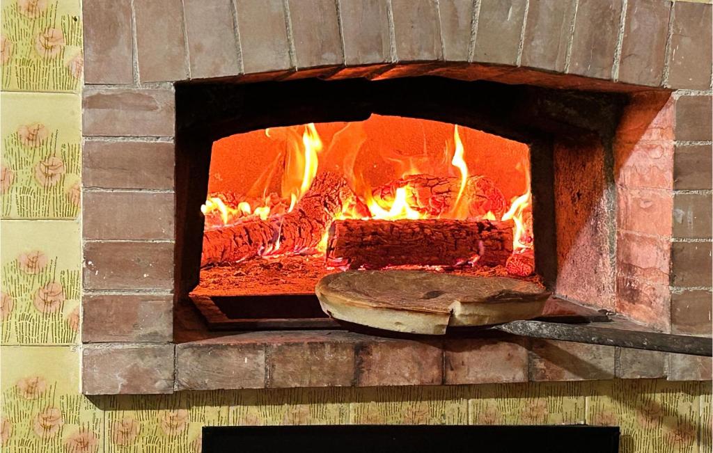 piec ceglany z ogniem w obiekcie Gorgeous Home In Carano With Kitchen w mieście Carano